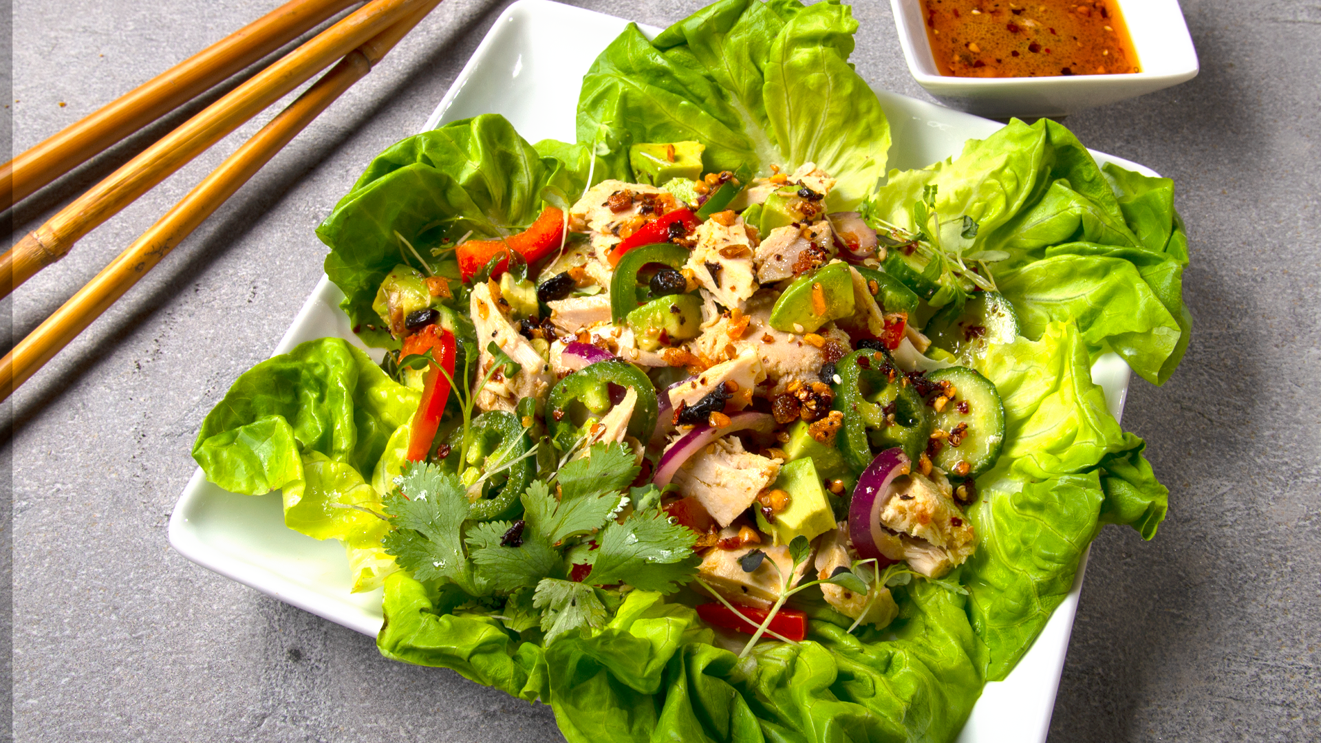 Square white plate with Boston lettuce and Mexican tuna salad. Small square saucer with oo’mämē Mexican chile infusion dressing. #tunasalad #myoomame