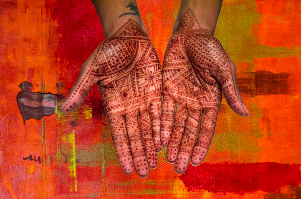 Hands with Moroccan Henna Design on orange colorful background