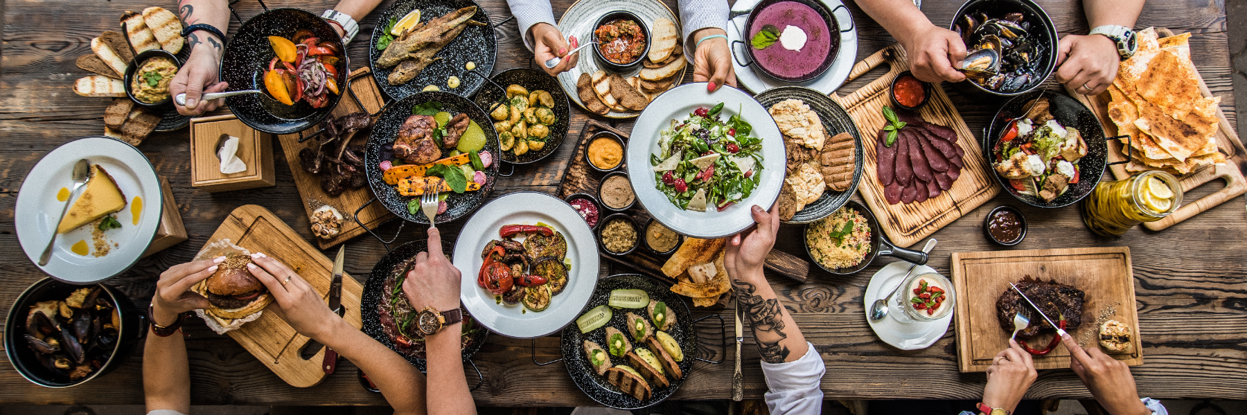 overhead shot of dinner table, filled with food and people breaking bread #myoomame