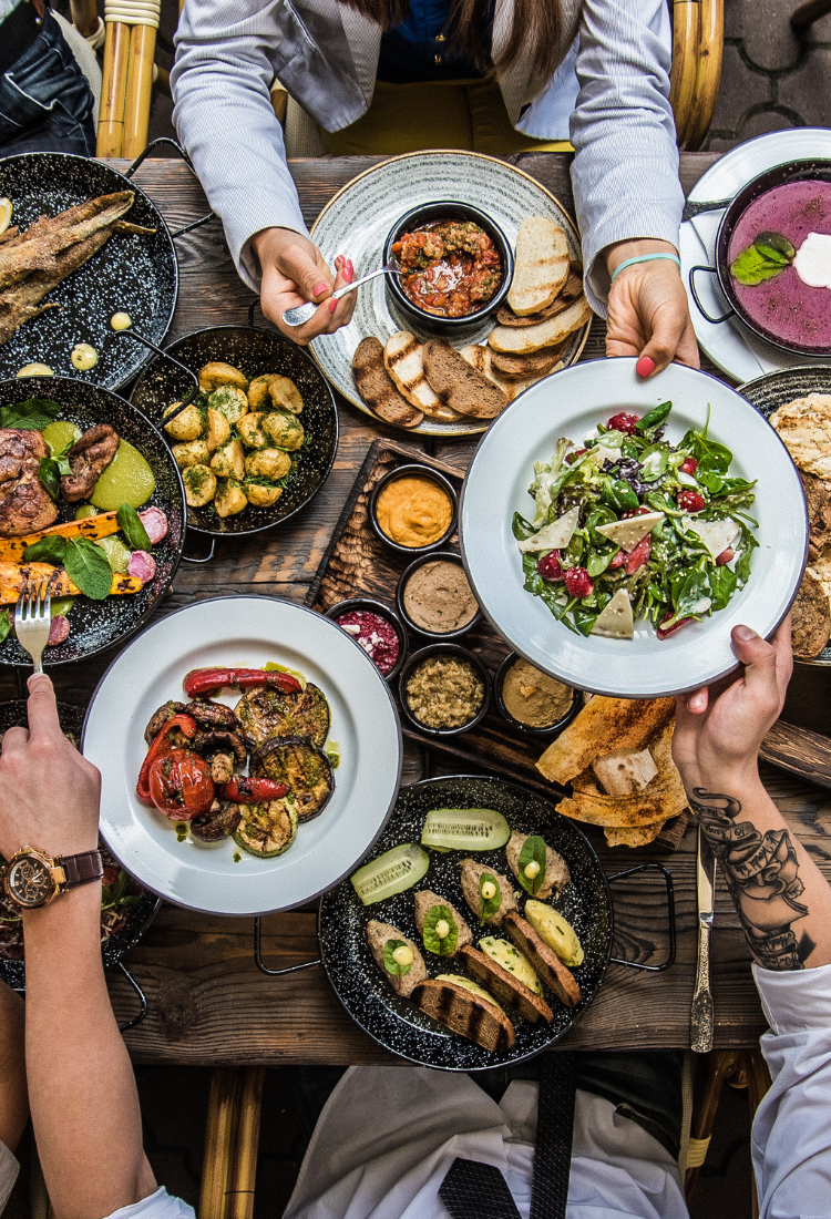 overhead shot of dinner table, filled with food and people breaking bread #myoomame