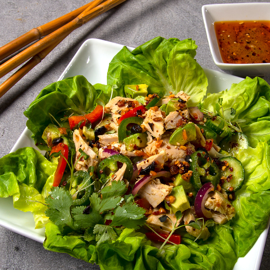 Square white plate with Boston lettuce and Mexican tuna salad. Small square saucer with oo’mämē Mexican chile crisp dressing. #tunasalad #myoomame